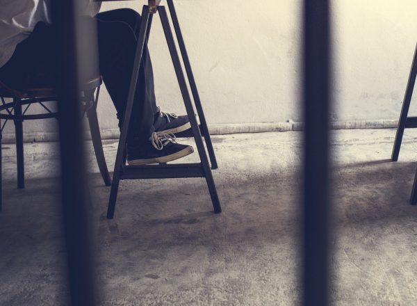 Closeup of pairs of legs in jail