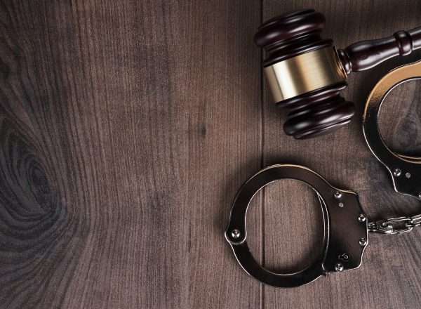 Handcuffs And Judge Gavel On Wooden Background