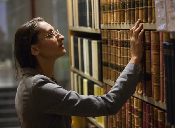Lawyer picking book in the law library at the university